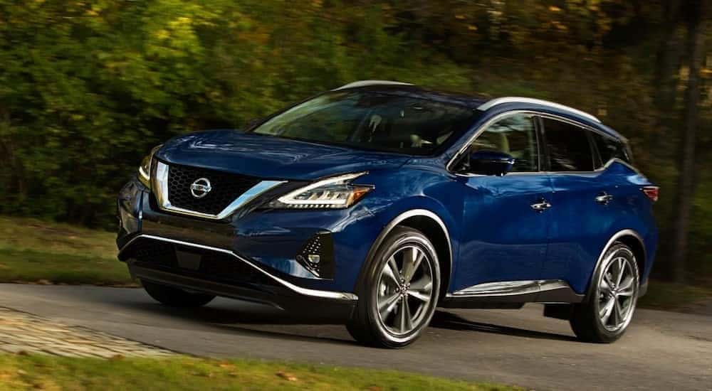 A blue Nissan model Murano on a test drive on a quiet street