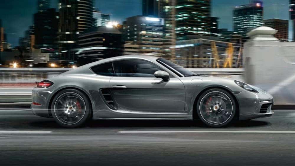 2025 718 cayman in silver driving at night in the city