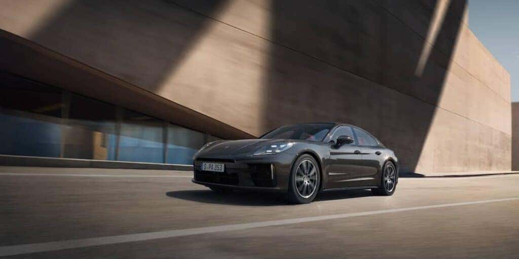 The Porsche Panamera front angle view against a modern architectural backdrop, emphasizing its bold and elegant design