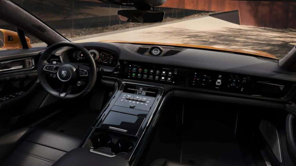 Interior of the Porsche Panamera highlighting its advanced dashboard, sleek controls, and luxurious black leather finish