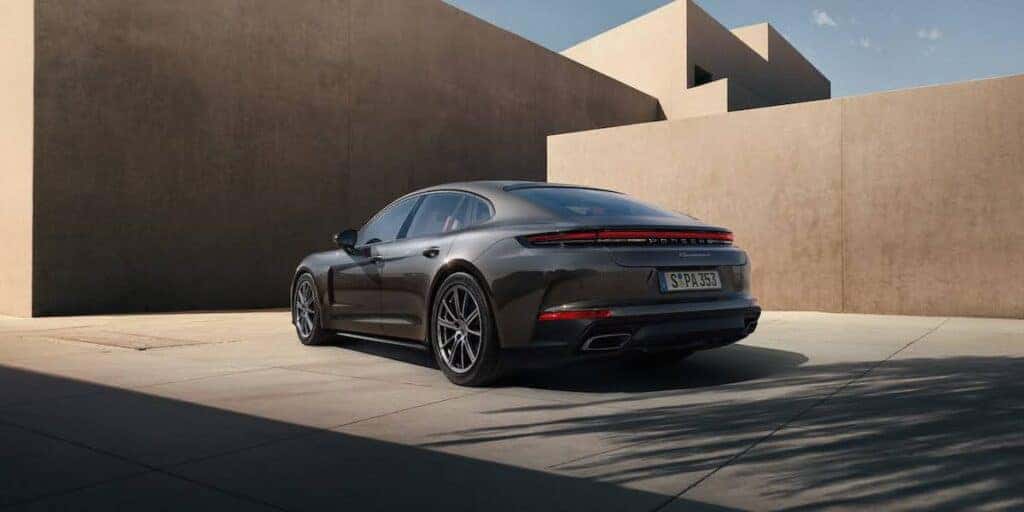 Rear view of the Porsche Panamera showcasing its sleek and aerodynamic design with a striking urban background