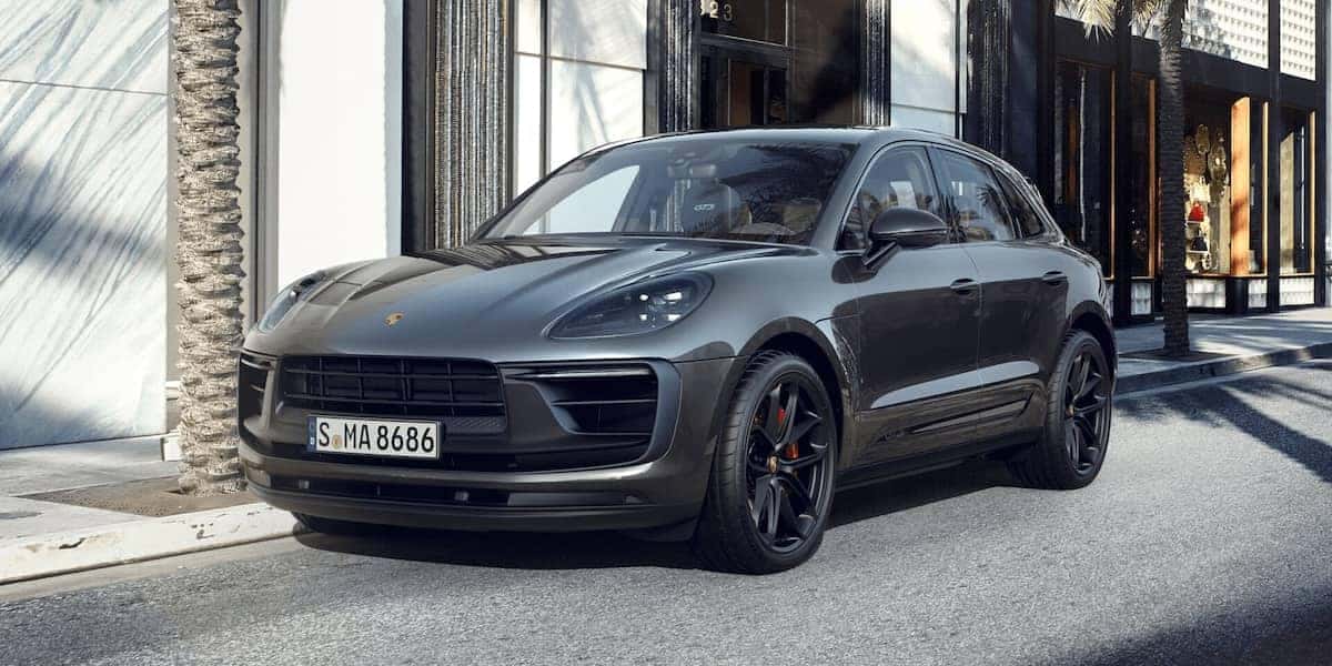 2025 Porsche Macan parked on a stylish city street, showcasing its sleek design and luxury SUV features