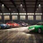 A lineup of classic Porsche models in a spacious industrial setting, showcasing various Porsche engines from the flat 6 to V8-powered performance machines.