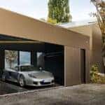 Silver Porsche Carrera GT parked in modern garage showcasing the iconic supercar's sleek design and distinctive side profile
