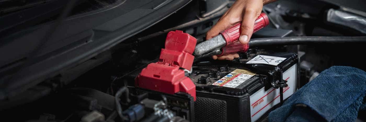 Premier Kia of Kenner technician testing a battery