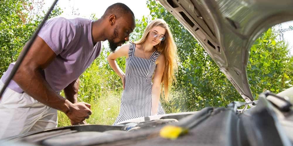 Couple checking their car in the summer