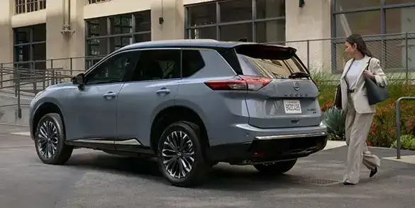 Professional women walking behind her Nissan Rogue