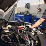 subaru mechanic opening hood of a subaru