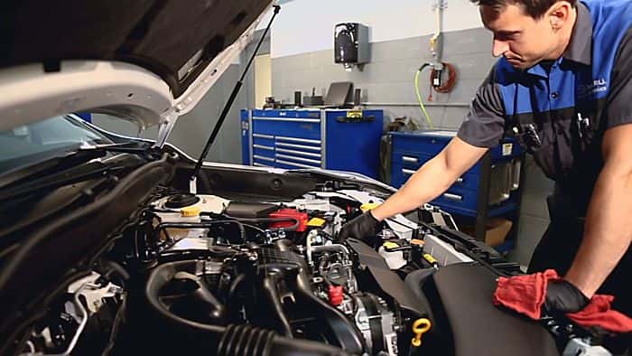 subaru mechanic opening hood of a subaru