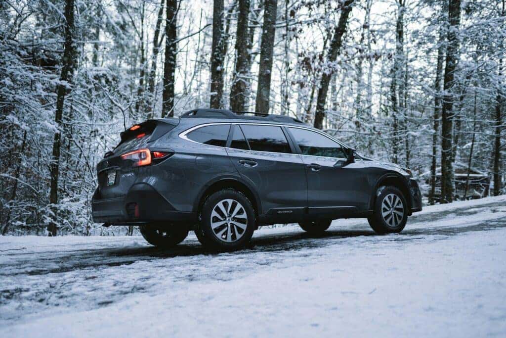black subaru outback on a snowy trail