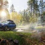 blue subaru outback off-roading in rain