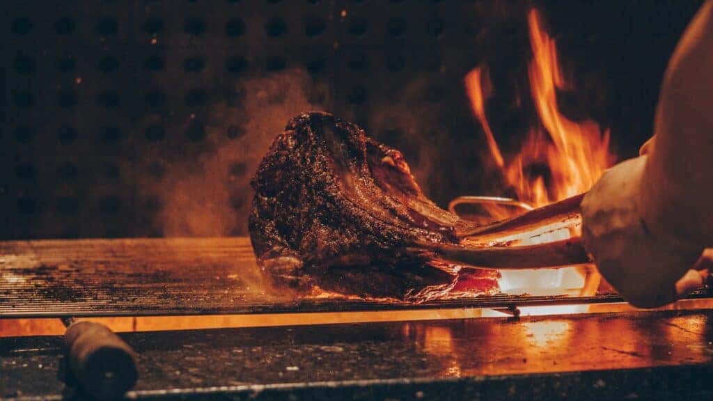 meat cooking on flame grill at bbq restaurant