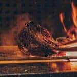 meat cooking on flame grill at bbq restaurant