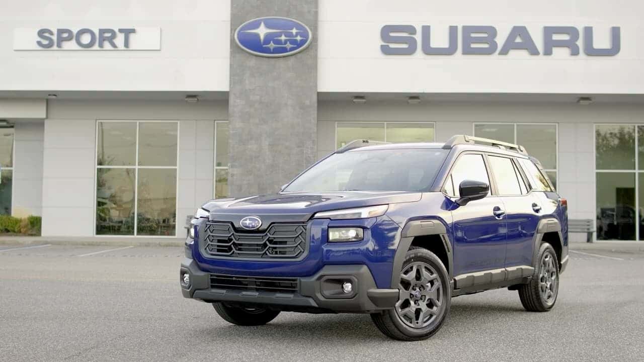 A blue 2026 Subaru Outback Wilderness parked on the front line outside the Sport Subaru South showroom.