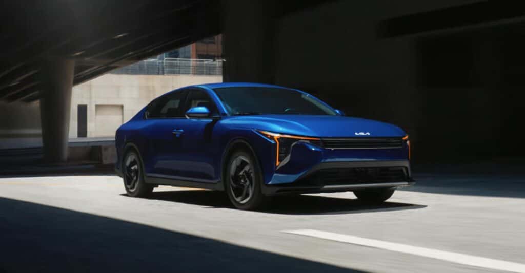 Blue-2025-Kia-K4-driving-under-overpass