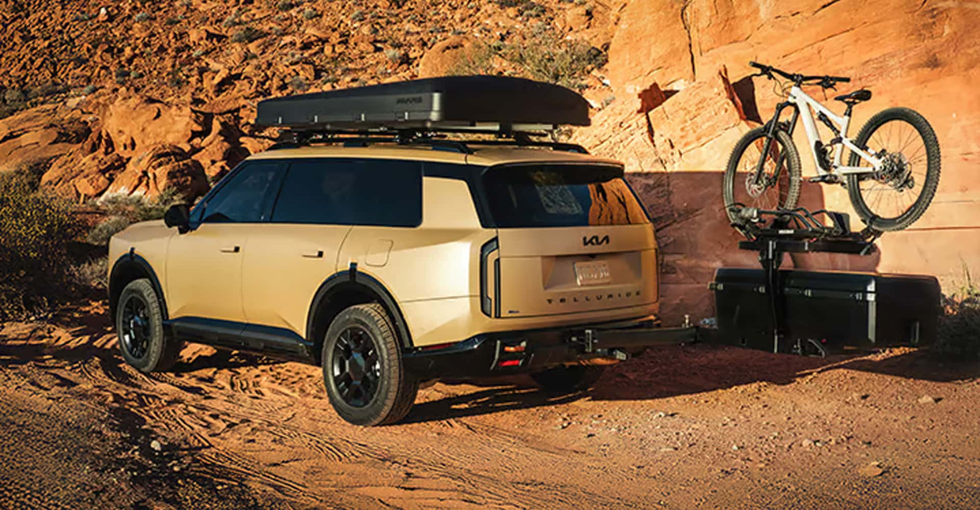 2027 Kia Telluride hauling bike up dirt road