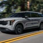 Gray 2026 Kia Carnival Hybrid driving down the road