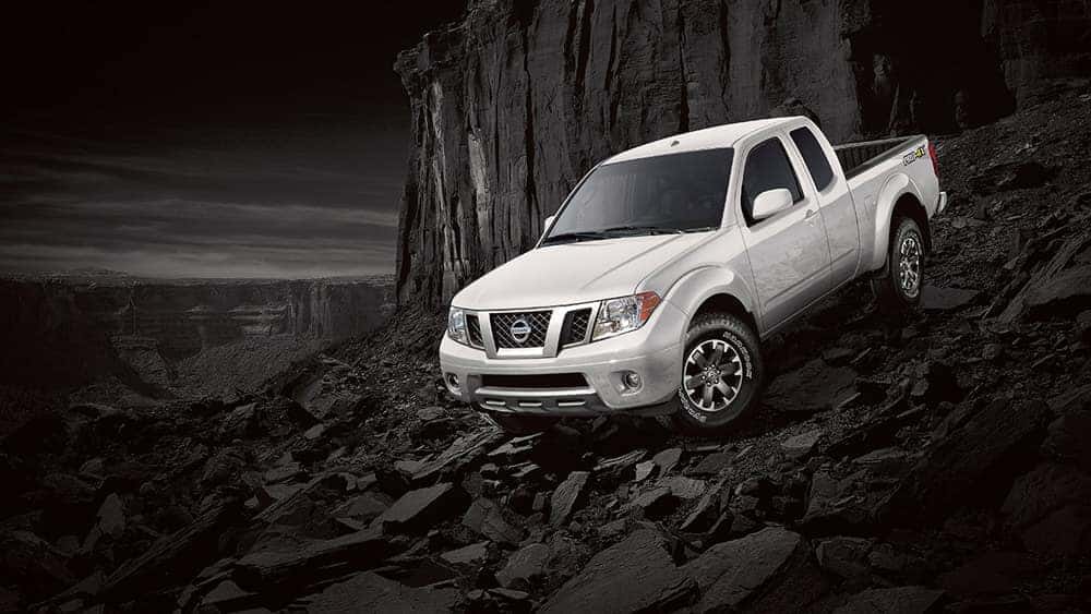 2019 Nissan Frontier White driving down a steep rocky hill