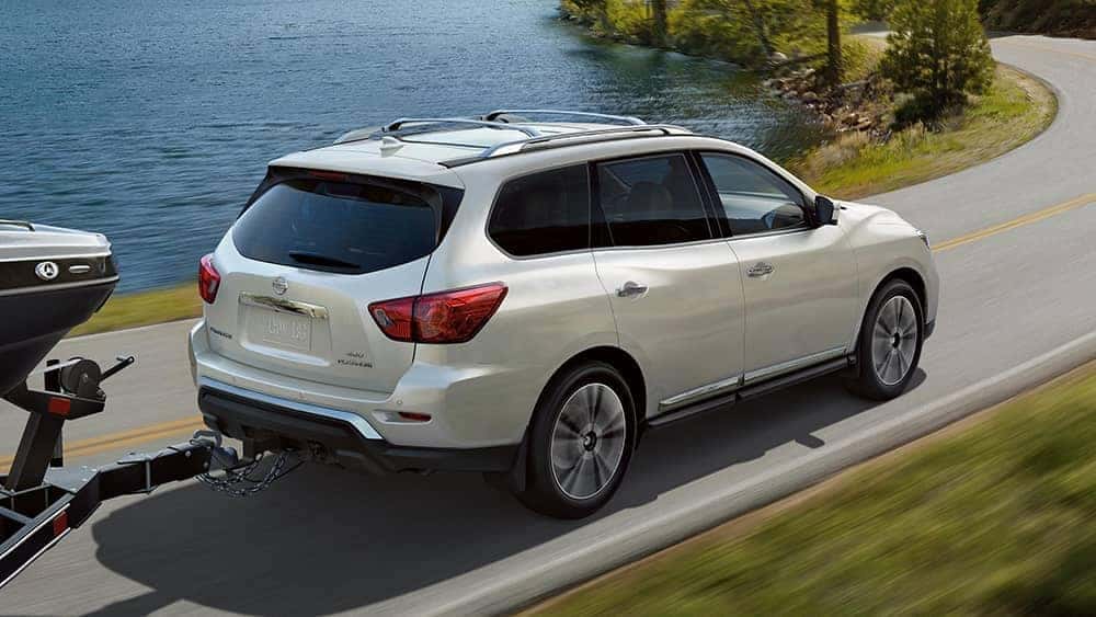 2020 Nissan Pathfinder towing a boat by a lake