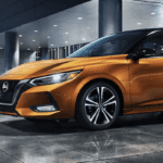 Orange 2021 Nissan Sentra parked in front of a building at night