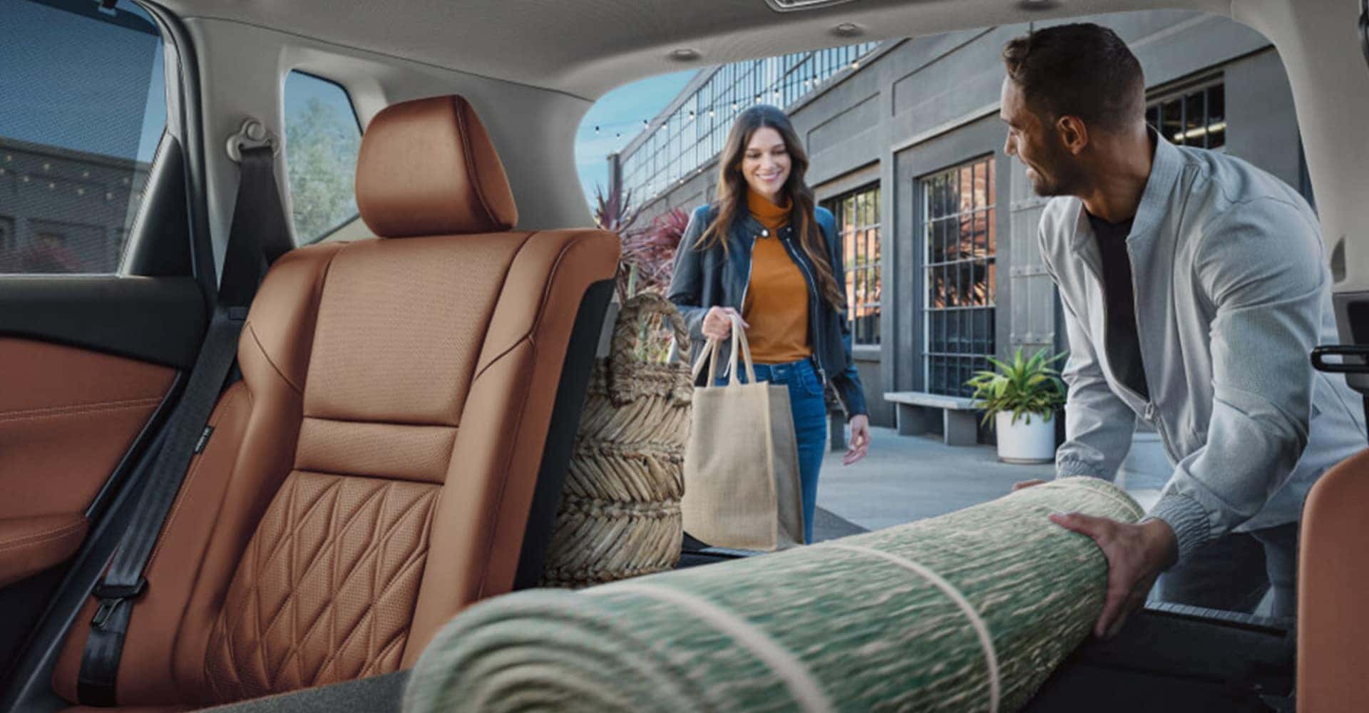 People Loading a Rug in the Trunk of their Nissan Rogue