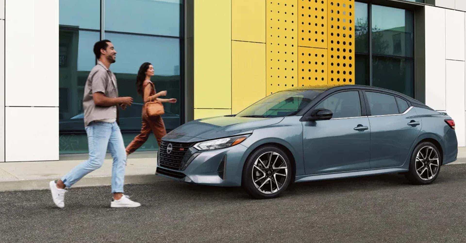 2025-nissan-sentra-parked-front-hotel-couple-approaching-car
