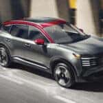 2026 nissan kicks driving down interstate in city