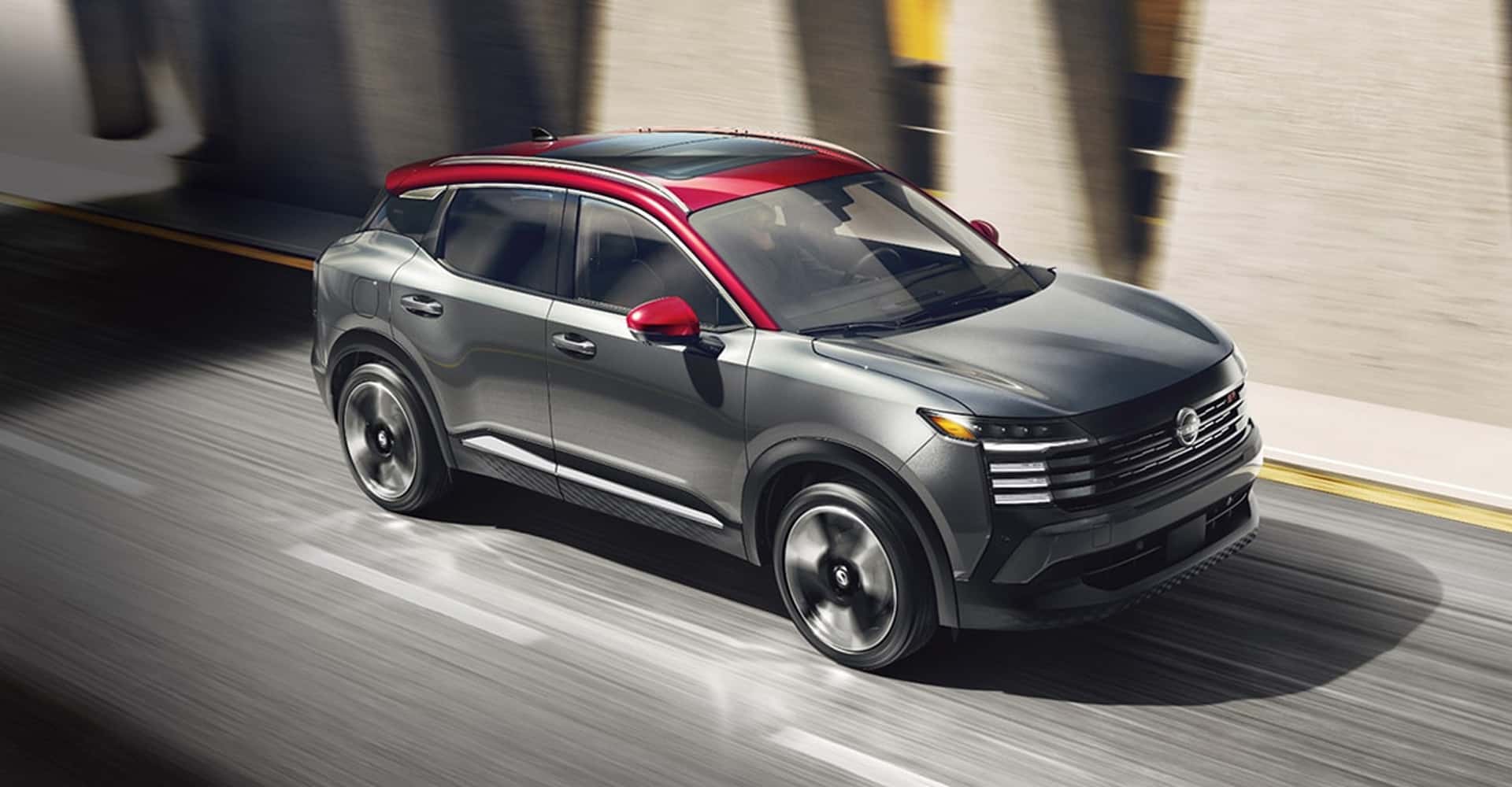 2026 nissan kicks driving down interstate in city