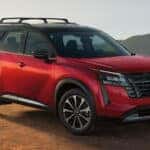 2026-nissan-pathfinder-front-three-quarter-view-red-exterior-mountain-terrain-lightbox-D