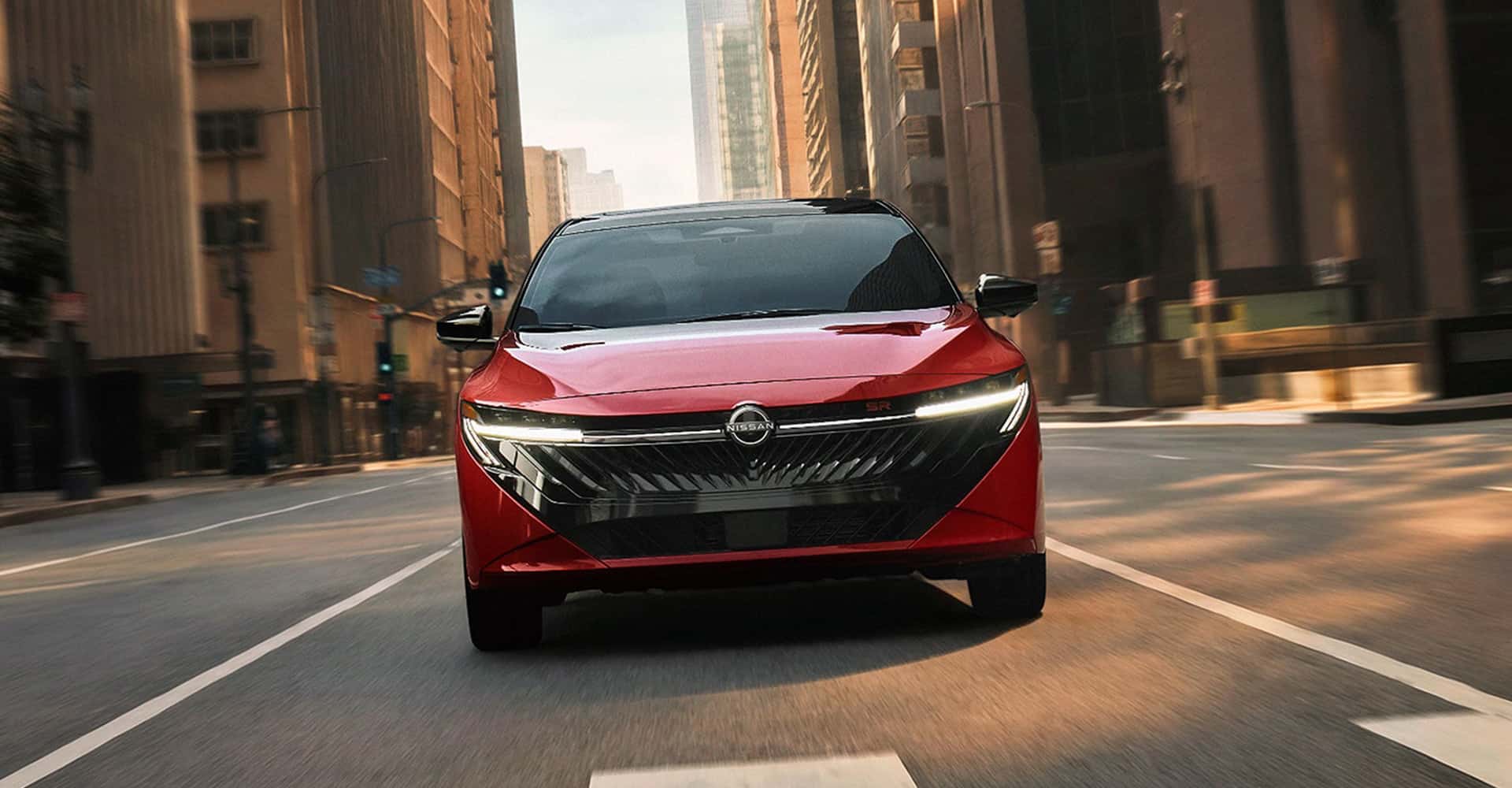 Front view 2026 Nissan Sentra red with headlights on