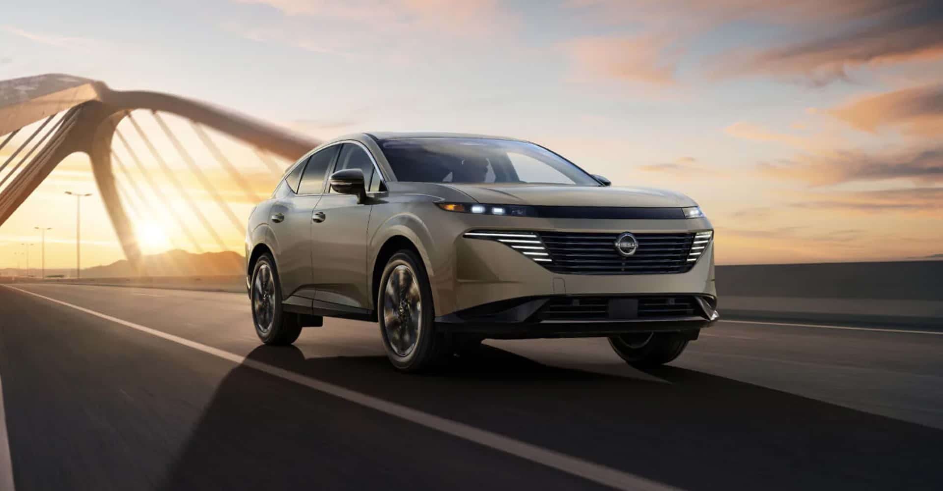 2026 Nissan Murano driving across bridge at sunset