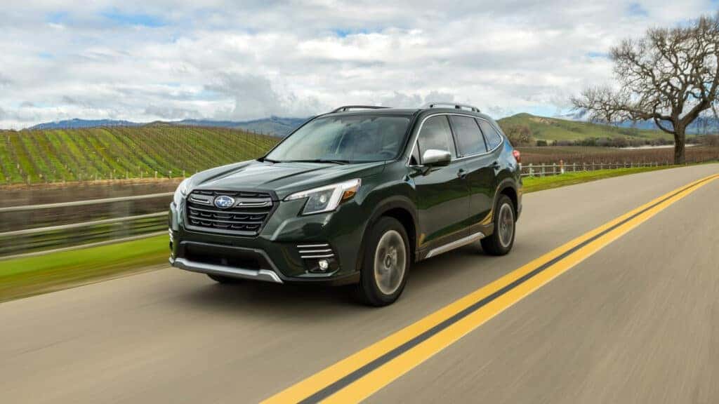 green forester driving by field