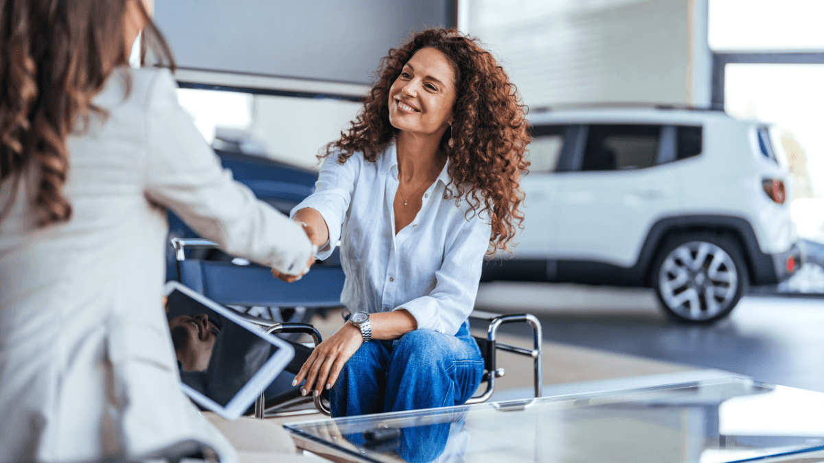 Happy woman shaking hands with a sales associate
