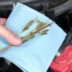 Auto mechanic checking oil