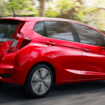 Red Honda Fit driving